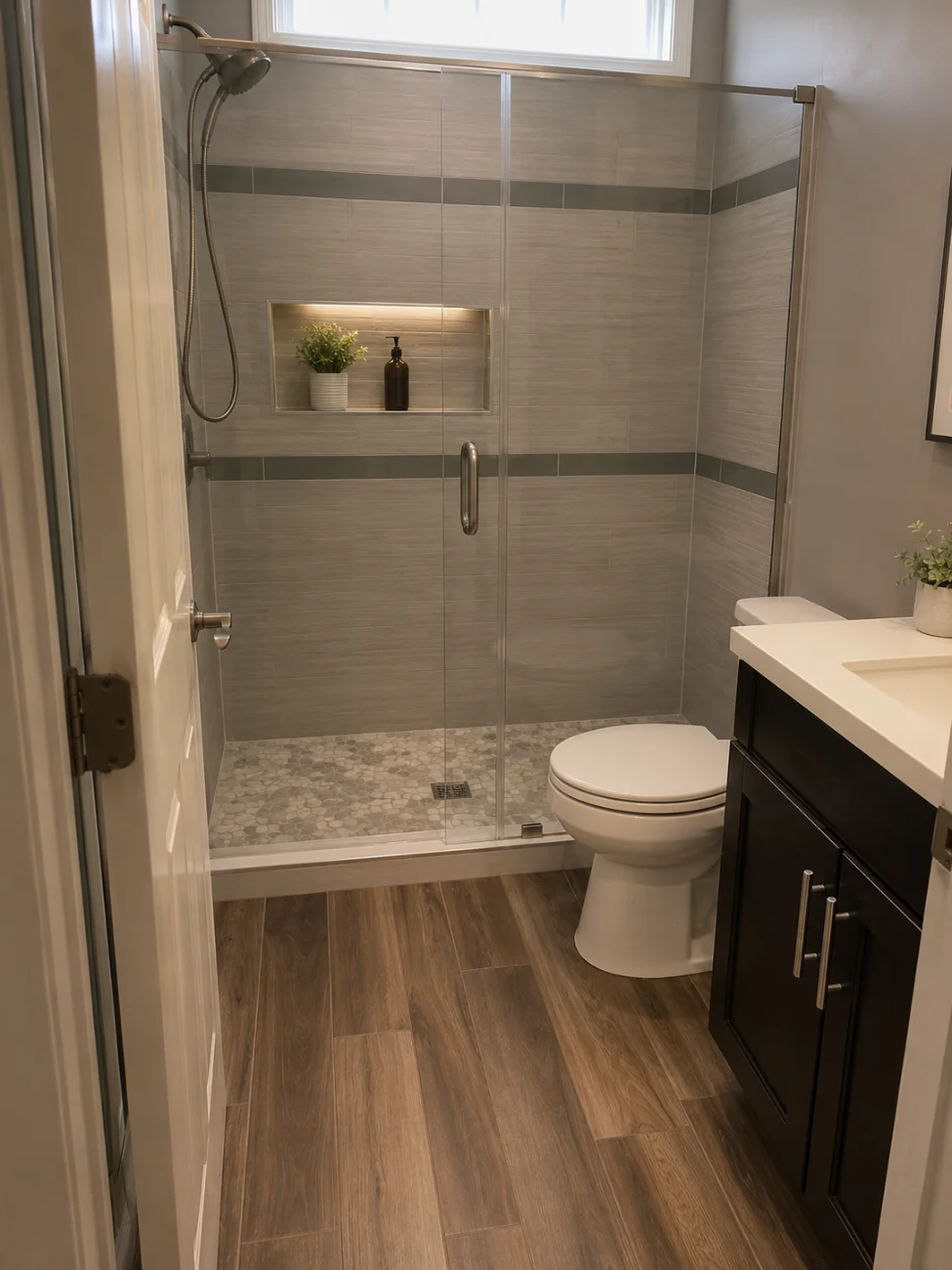 Baño remodelado con ducha de azulejos y puerta de vidrio